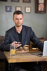 Image showing Businessman With Mobilephone And Laptop Having Sandwich