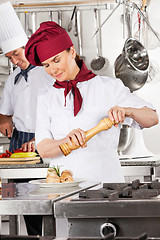 Image showing Female Chef Seasoning Salmon Roll
