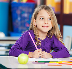 Image showing Thoughtful Girl With Sketch Pen And Paper In Classroom