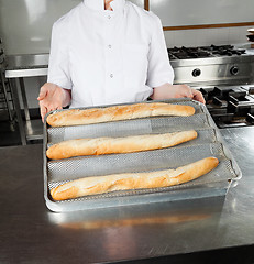 Image showing Female Chef Presenting Loafs In Kitchen