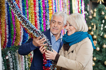 Image showing Couple Selecting Tinsels At Store