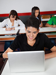 Image showing Happy Teenage Schoolboy Using Laptop