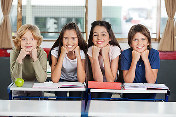 Image showing Schoolchildren Leaning At Desk Together