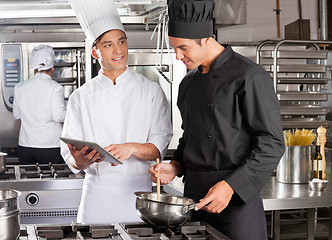 Image showing Male Chef Assisting Colleague In Preparing Food