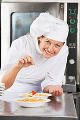 Image showing Happy Chef Adding Spices To Dish