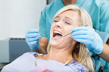 Image showing Dentist Treating A Female Patient At Clinic