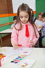 Image showing Girl With Watercolor And Paintbrush Painting At Desk