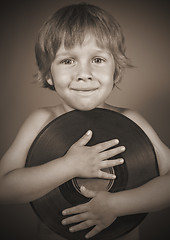 Image showing boy with a record smiles