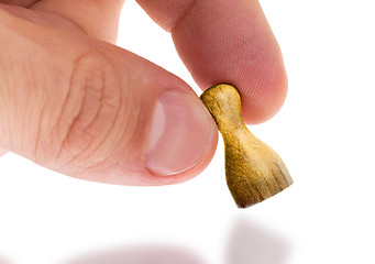 Image showing Hand holding wooden pawn, painting, selective focus