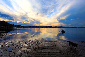 Image showing Rowboat coming to shore in late afternoon sunset