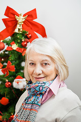 Image showing Smiling Senior Woman Against Christmas Tree