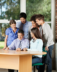 Image showing Students And Teacher Looking At Digital Tablet In Classroom