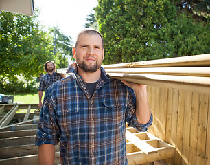 Image showing Carpenters Carrying Lumbers On Shoulders At Construction Site