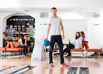 Image showing Confident Man Holding Ball in Bowling Alley