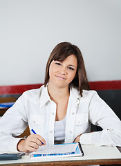 Image showing Beautiful Teenage Schoolgirl Sitting At Desk