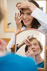 Image showing Optometrist Teaching Senior Woman To Insert Contact Lens