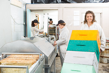 Image showing Female Beekeeper Holding Trolley Of Stacked Honeycomb Crates