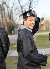 Image showing Student In Graduation Gown Holding Certificate On Campus