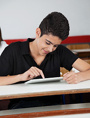 Image showing Happy Teenage Schoolboy Using Tablet At Desk