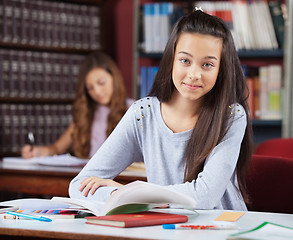 Image showing Beautiful Teenage Schoolgirl With Books Sitting In Library