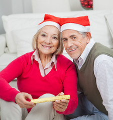 Image showing Smiling Senior Couple With Christmas Present