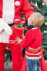 Image showing Santa Claus Giving Present To Boy