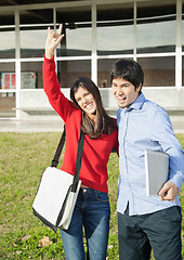 Image showing Man With Friend Gesturing Devil Horns On College Campus