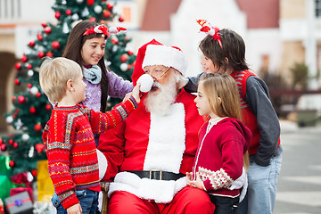 Image showing Children Playing With Santa Claus's Hat