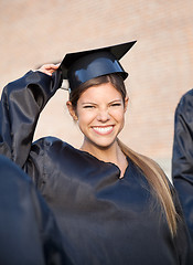 Image showing Woman In Graduation Gown Holding Mortar Board On Campus