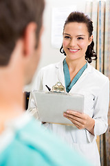 Image showing Female Doctor With Clipboard Looking At Patient