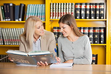 Image showing Teacher Holding Book While Explaining Student In Library