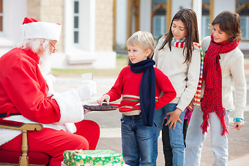 Image showing Boy Taking Biscuits From Santa Claus
