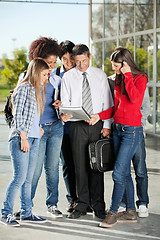 Image showing Professor Holding Book While Standing With Students On Campus