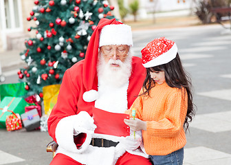 Image showing Girl Showing Wish List To Santa Claus