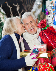 Image showing Woman Kissing Happy Man With Christmas Presents