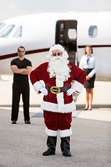 Image showing Santa Standing With Bodyguard And Airhostess Against Private Jet