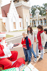 Image showing Santa Claus Offering Biscuits To Children