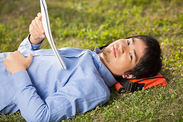 Image showing Student With Book Lying On Grass At University Campus