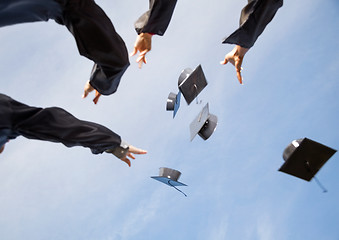 Image showing Students Throwing Mortar Boards In Air Against Sky