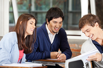 Image showing Students Discussing Over Book In Classroom