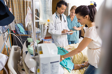 Image showing Woman Looking At Patient While Doctor And Nurse Examining Report