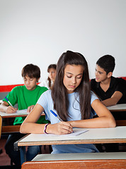 Image showing Female Student Writing Paper At Desk In Examination