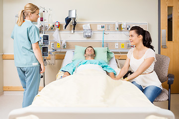 Image showing Woman Holding Patient's Hand While Looking At Nurse