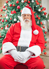 Image showing Santa Claus Sitting Against Christmas Tree