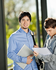 Image showing Male Student With Friend Reading Book In Campus