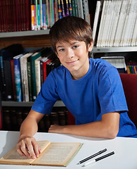 Image showing Teenage Schoolboy Smiling While Sitting In Library