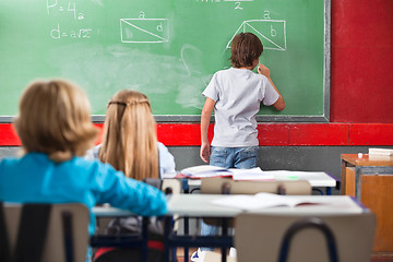 Image showing Schoolboy Writing On Greenboard In Classroom