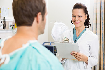 Image showing Doctor With Clipboard Examining Patient's Medical Report