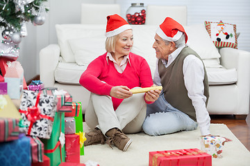Image showing Couple Wearing Santa Hats Looking At Each Other