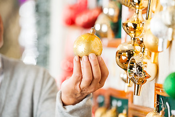 Image showing Man Holding Golden Christmas Bauble At Store